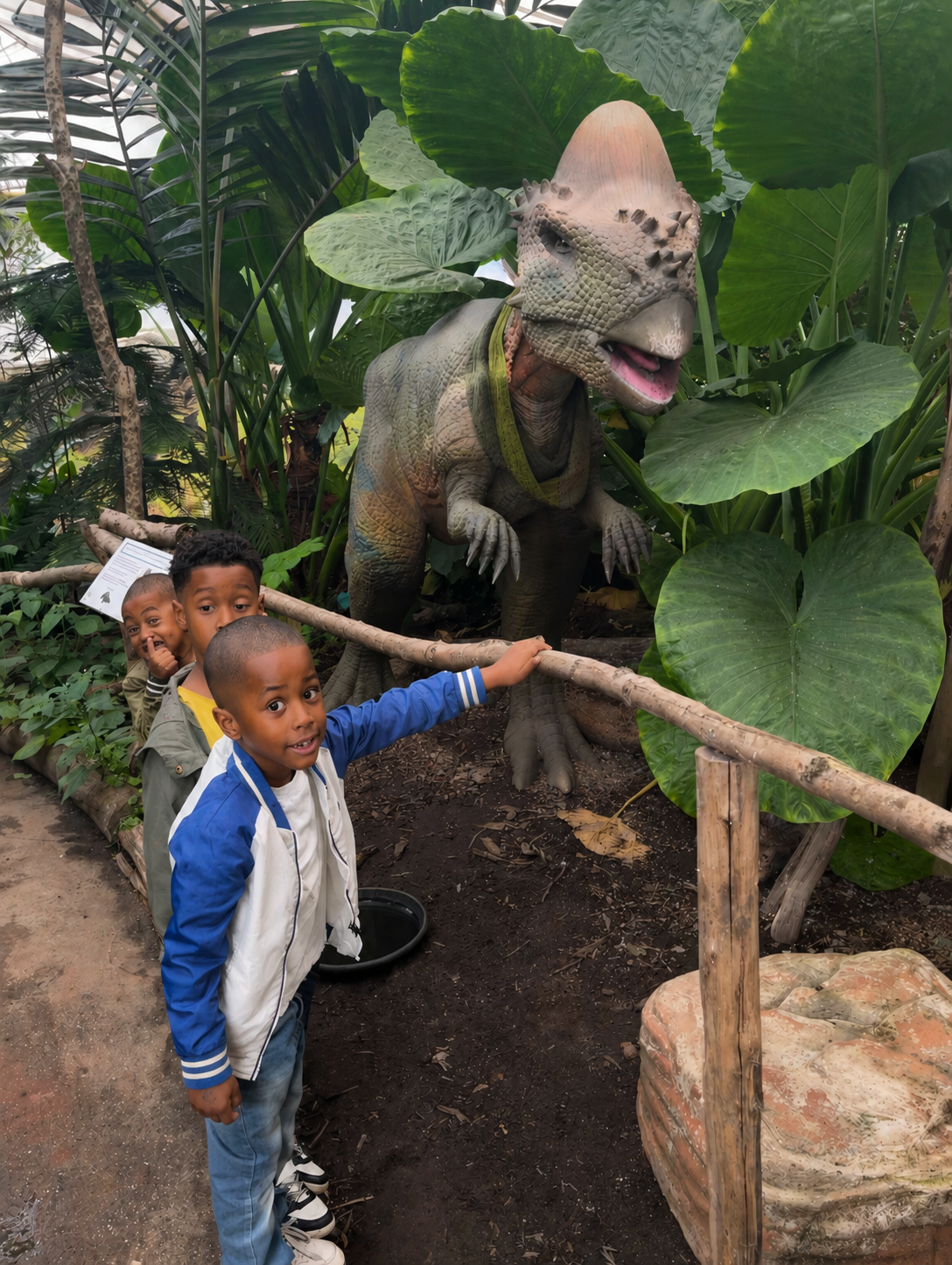 Kinderen bij een dinosaurus tijdens een dagje uit.